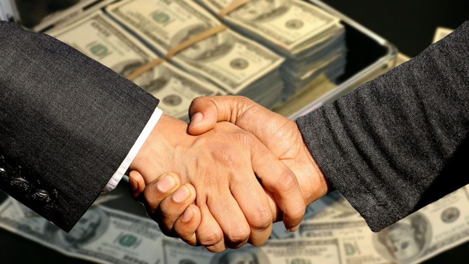 Apretón de manos sobre billetes